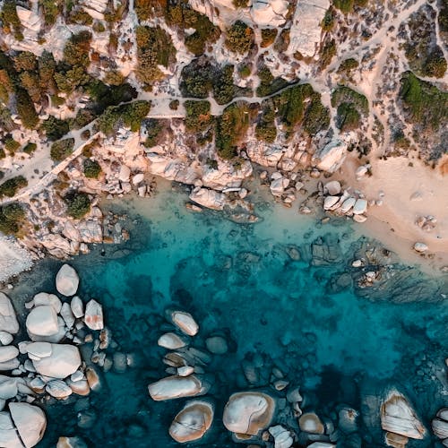 Aerial View of a Rocky Slope Above the Turquoise Sea