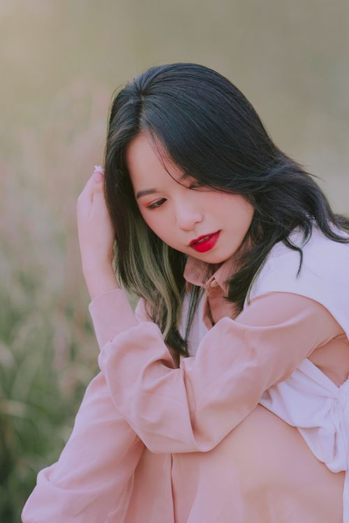 Free A serene portrait of a woman sitting gracefully amidst a natural setting, showcasing beauty and elegance. Stock Photo