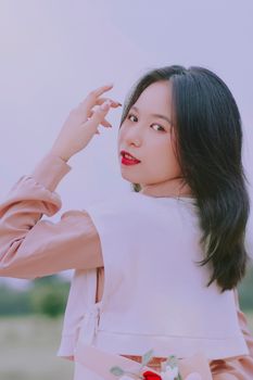 Stylish young woman in soft pastels posing outdoors with a confident look.