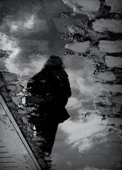 Silhouette reflection in a puddle on a rainy street in Neishabur.