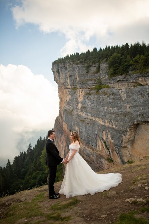 Bride and Groom Standing on the Background of a Cliff 