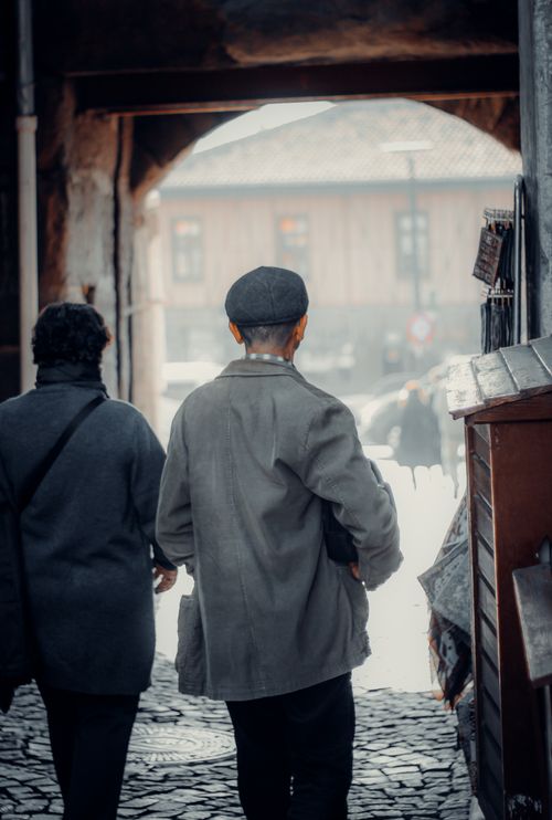 Free Two adults walking through cobblestone streets in an old town setting in Türkiye. Stock Photo