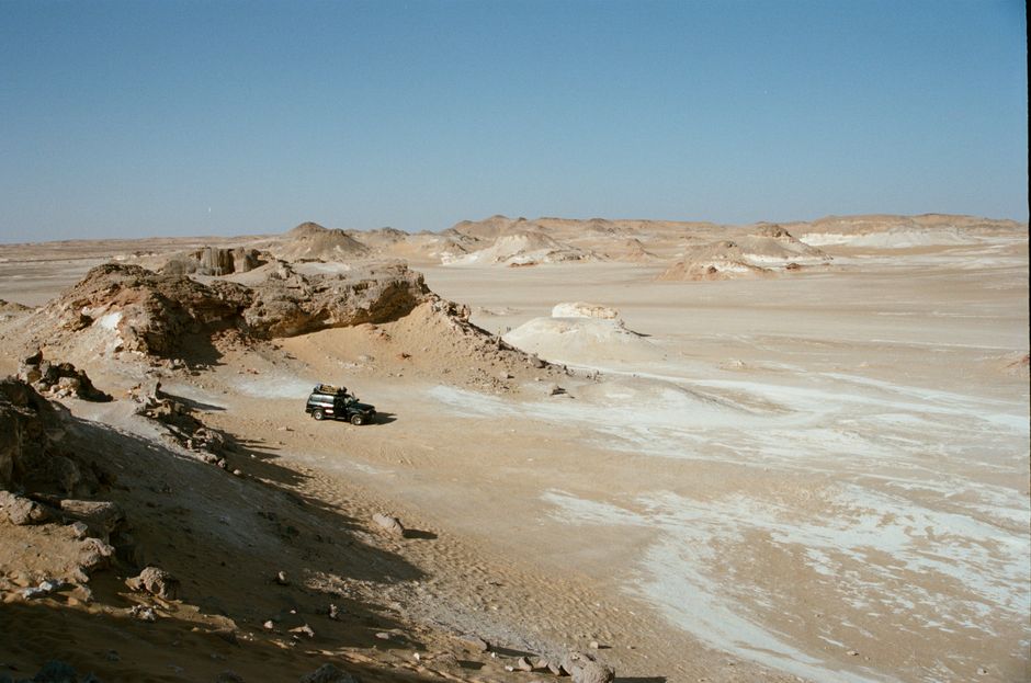 Explore the arid landscape of Farafra Desert with an off-road vehicle.