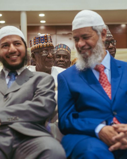 Free A diverse group of men in traditional and business attire at a meeting, smiling together. Stock Photo