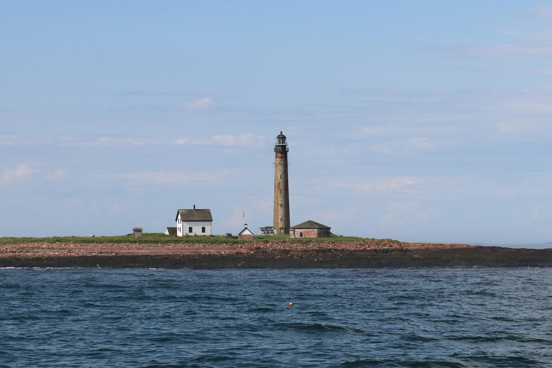 Coast with a Small House and a Lighthouse