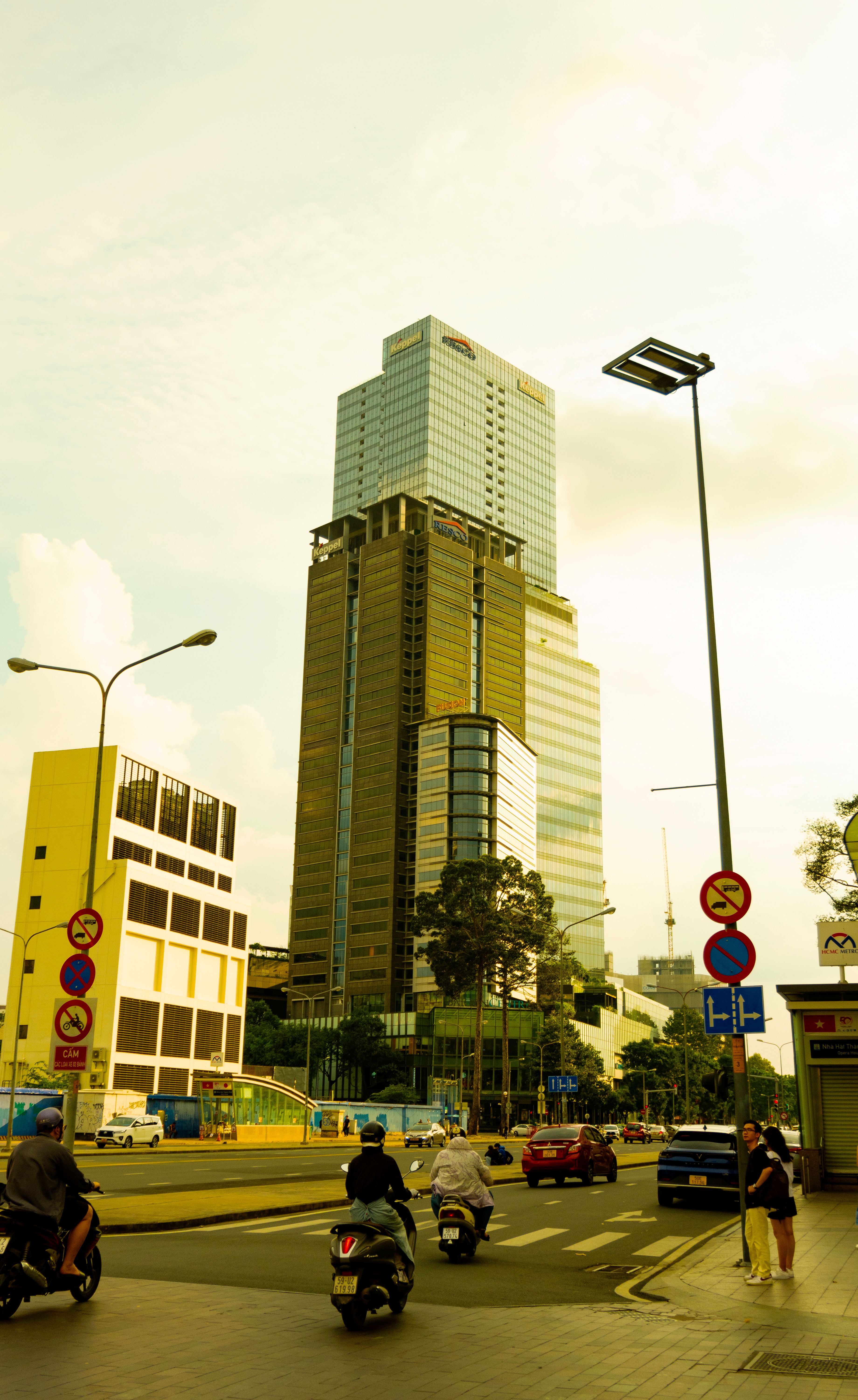 A bustling city street with modern skyscrapers in Ho Chi Minh City, Vietnam.