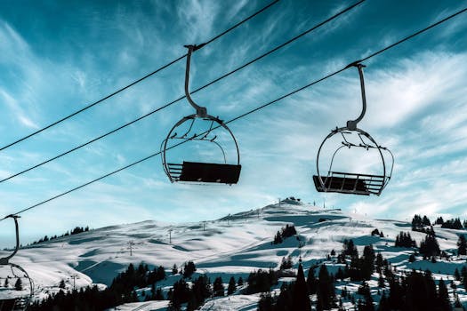 Scenic view of a ski lift against snowy mountains in Hauteluce, France, capturing winter beauty.