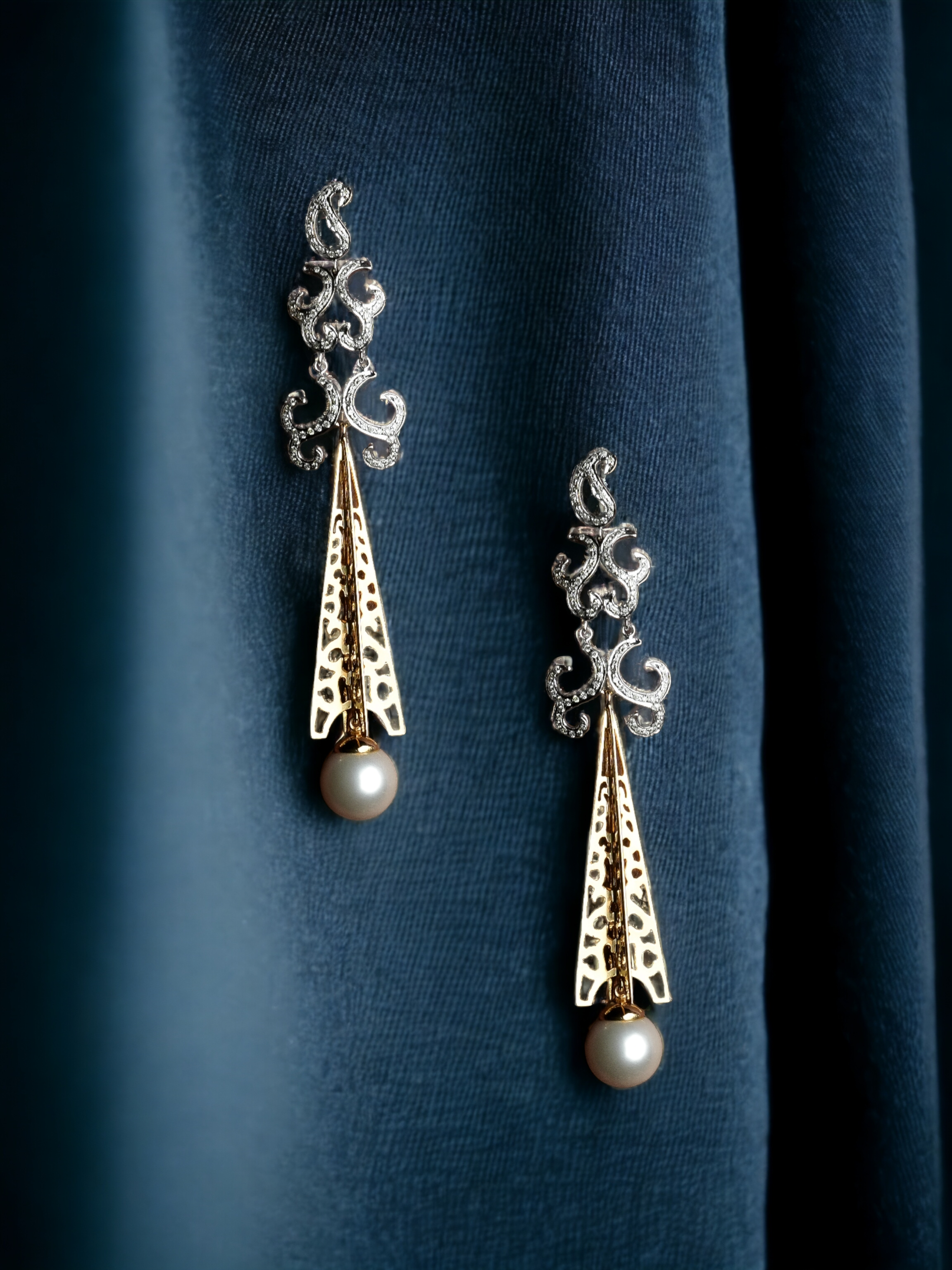 Brincos de ouro sofisticados com pérolas, perfeitos para exibições de moda luxuosa.