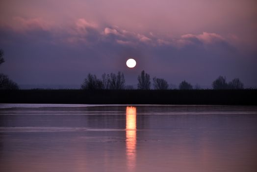 Beautiful sunset with a vibrant sky reflecting on still water.