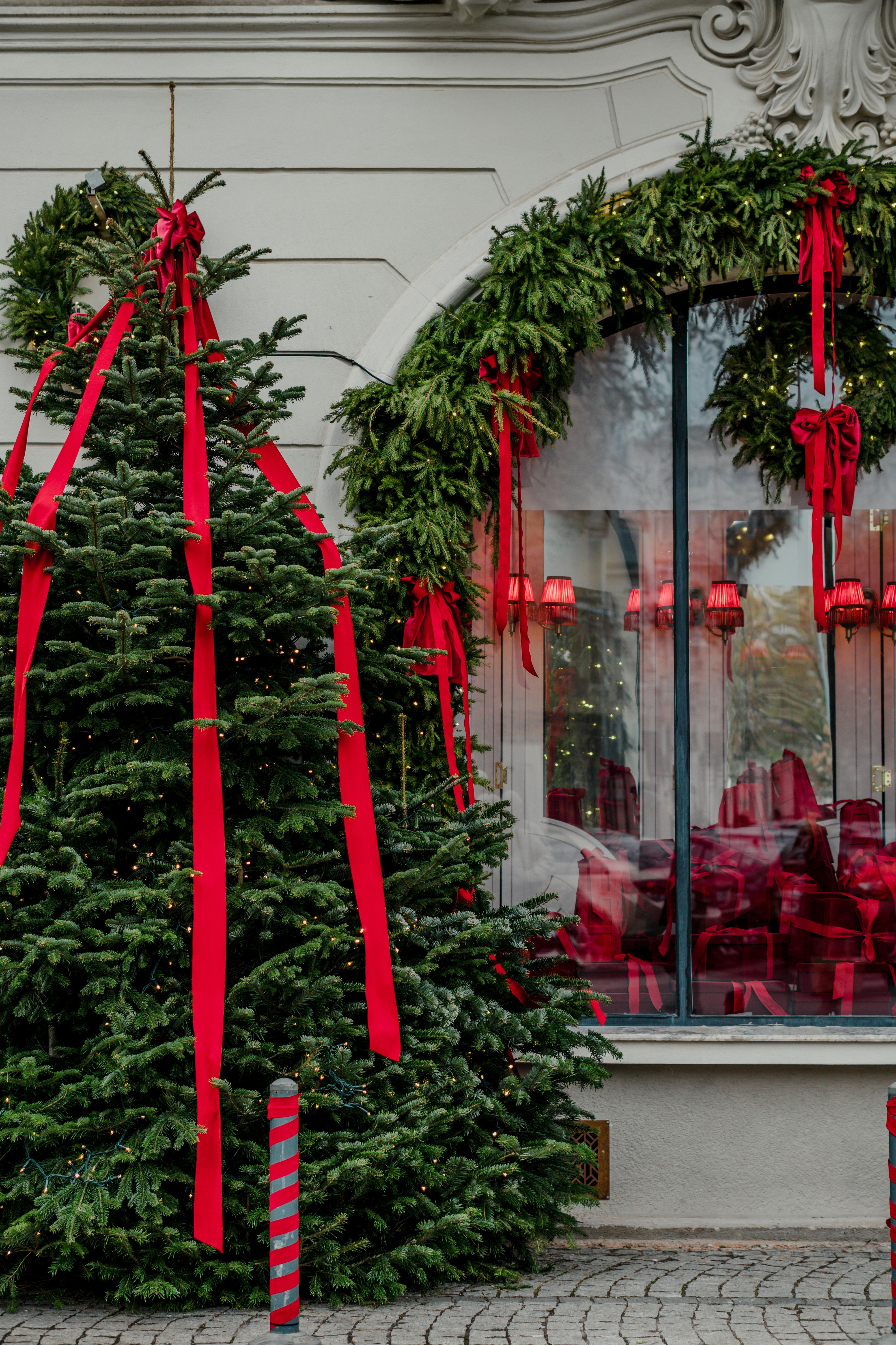Elegant Christmas tree and storefront in Bucharest adorned with festive ribbons and decorations.