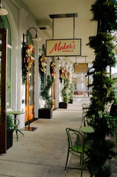 Charming coffee shop entrance decorated for Christmas with wreaths and greenery.