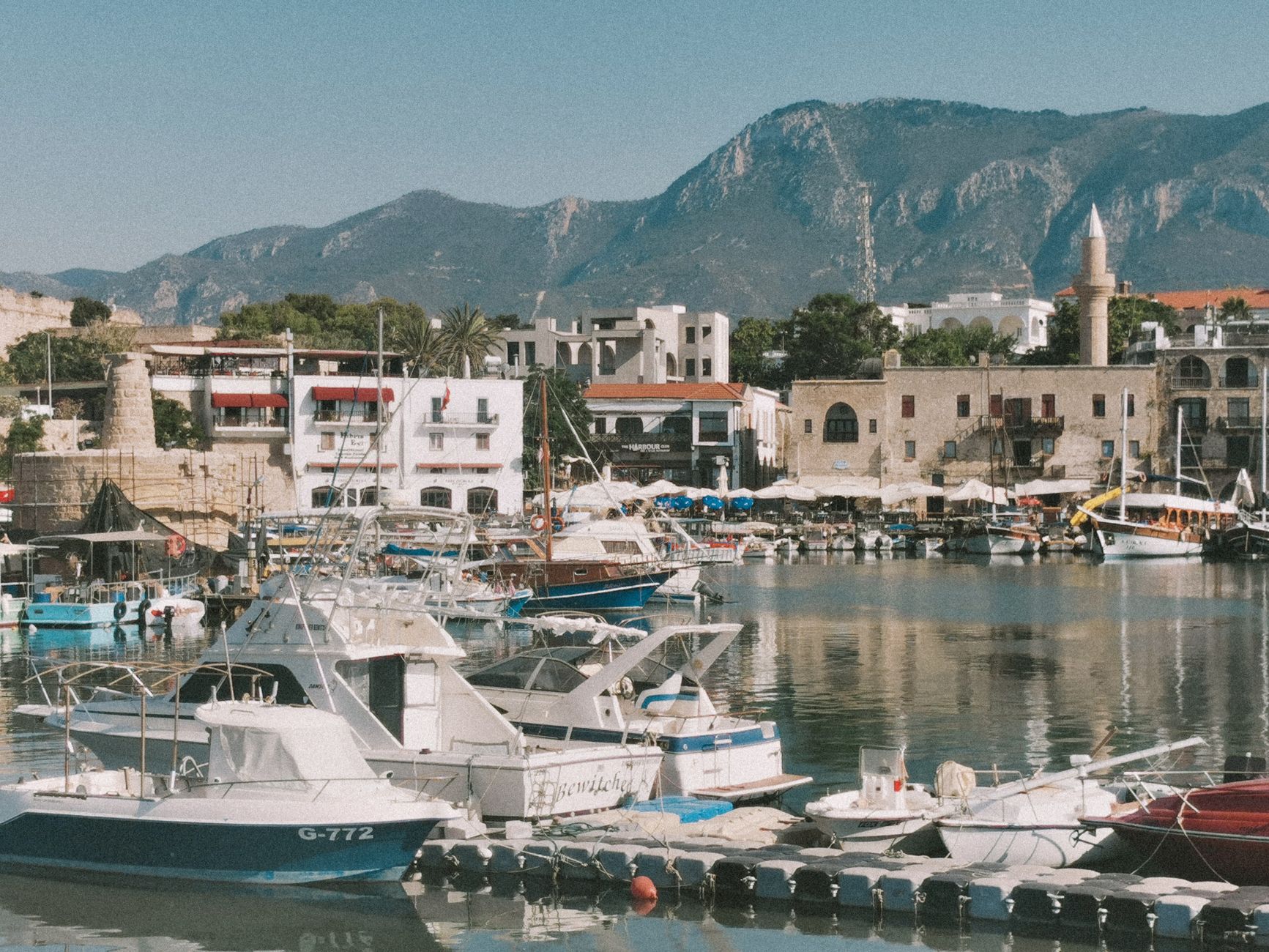 Horseshoe-shaped stone harbour at Kyrenia with fishing boats and a castle at one end