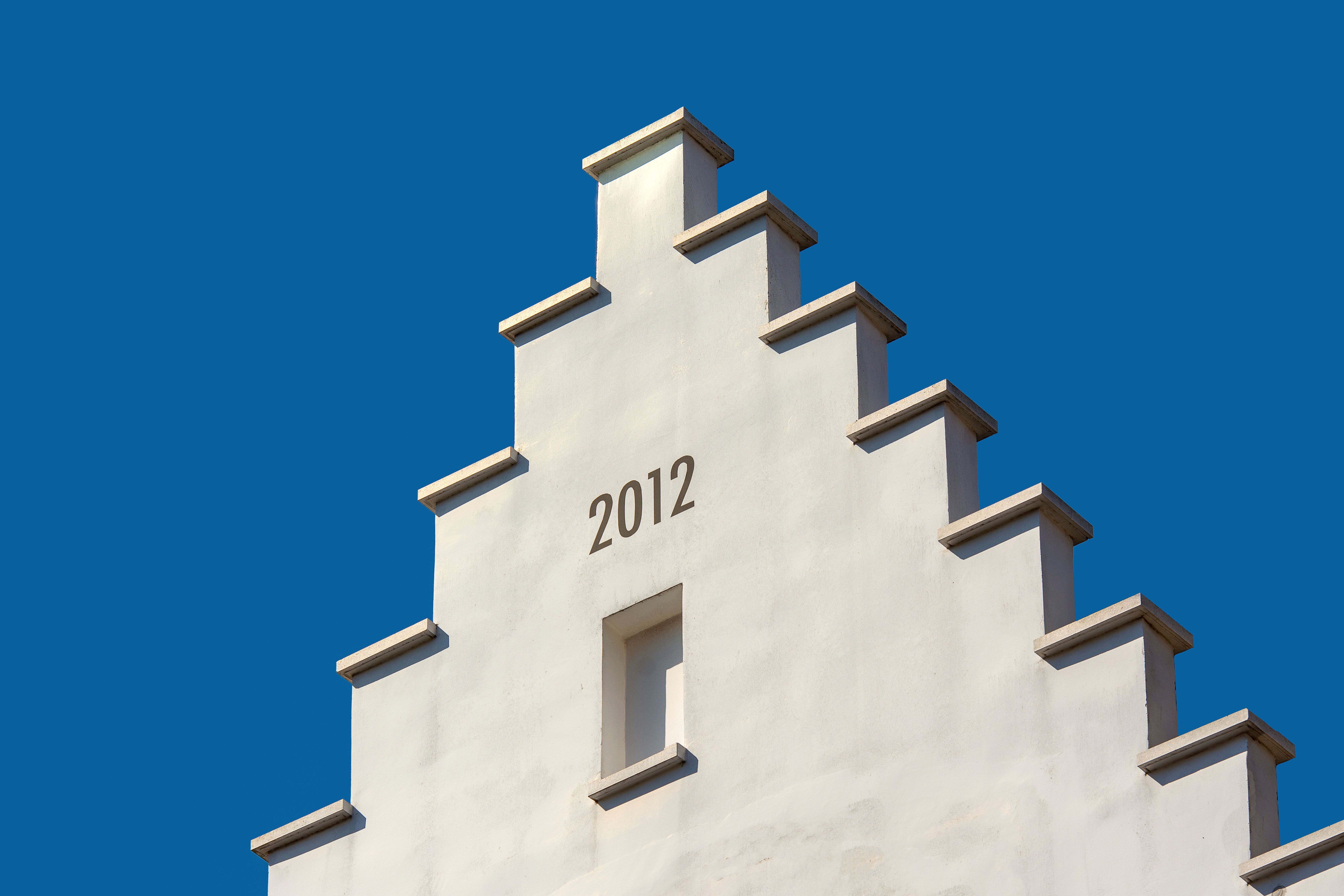 Close-up of a modern white building facade with stepped design and minimalist style.