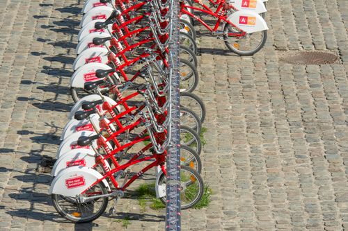 Rând de biciclete roșii de închiriat pe o stradă pavată din Antwerp