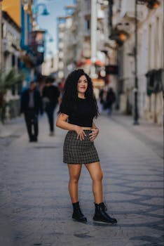 Fashionable young woman in a modern city street, showcasing casual style with confidence.