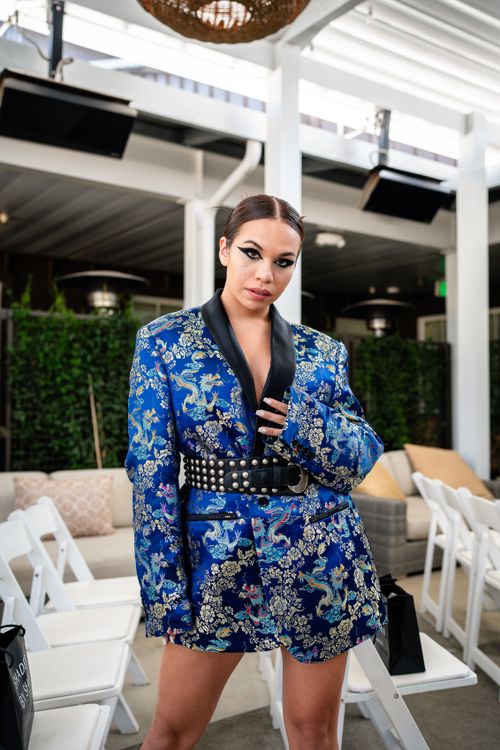 Free Stylish woman in a blue floral blazer posing confidently indoors. Stock Photo
