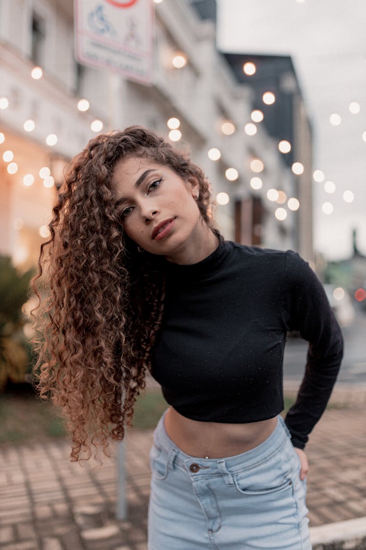 Portrait Of Brunette Woman With Curly Hair On A Street