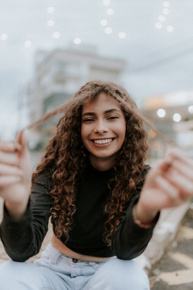 Portrait Of Brunette Woman With Curly Hair Smiling 