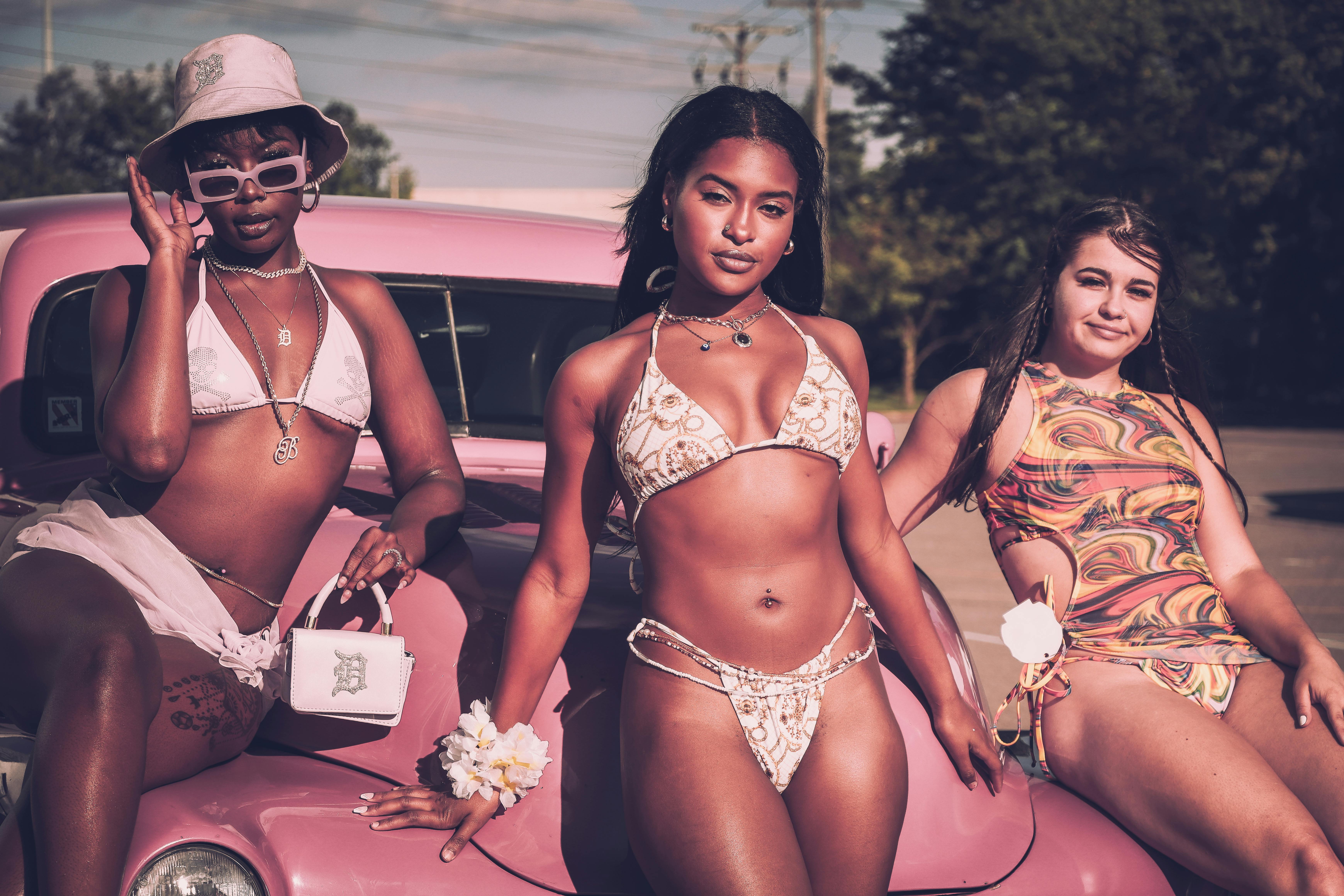 Young Women in Bikinis Sitting on a Car Hood · Free Stock Photo