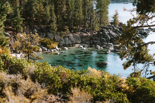 Captivating view of Lake Tahoe's emerald waters surrounded by lush forest and rocky shoreline.