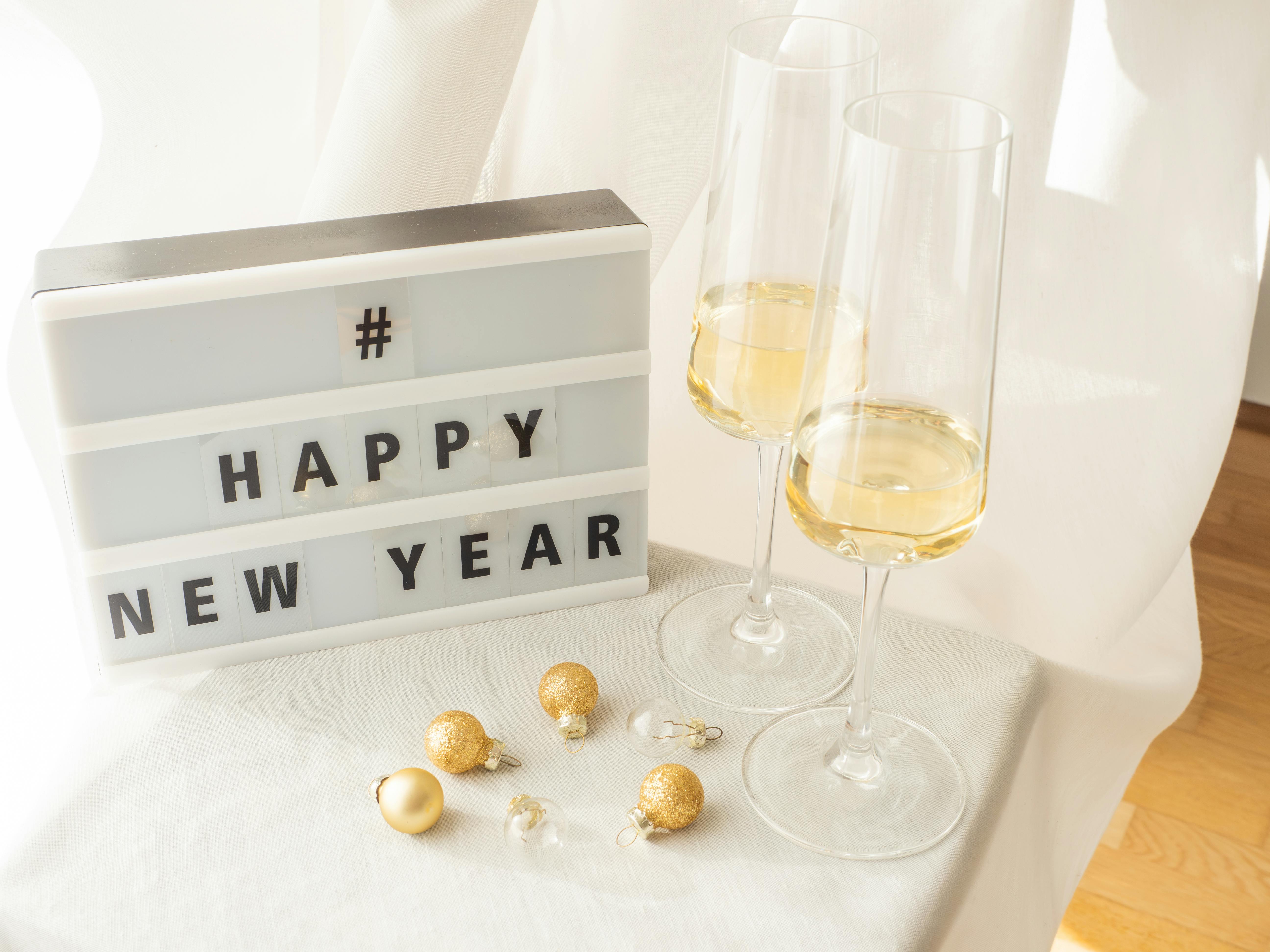 Cheerful New Year setup with champagne glasses and festive decor on a bright table.