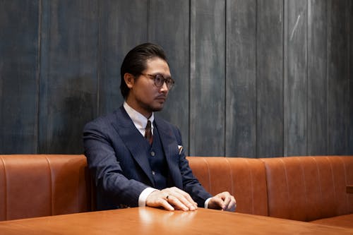 Man in a Suit Sitting in a Booth Seat