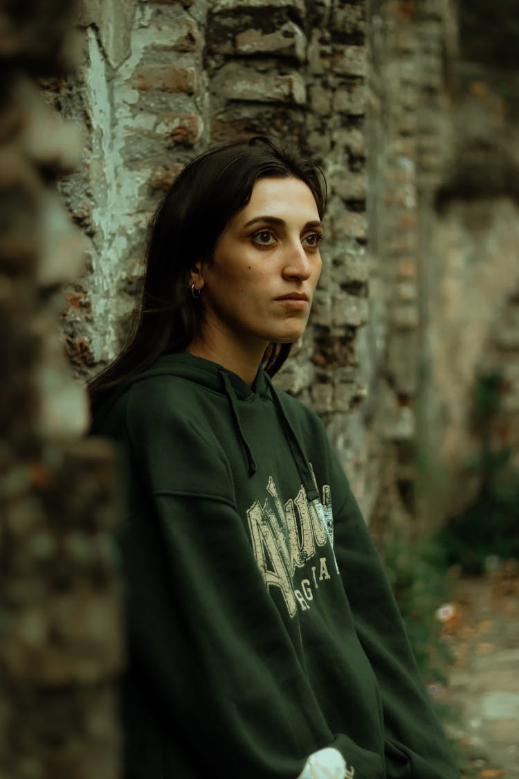 Young Woman In A Hoodie Sitting Outside 