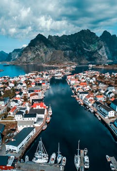 挪威一个古色古香的村庄，周围环绕着雄伟的山脉和平静的大海，鸟瞰图令人叹为观止