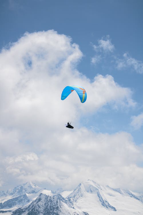 A person paragliding over a mountain range