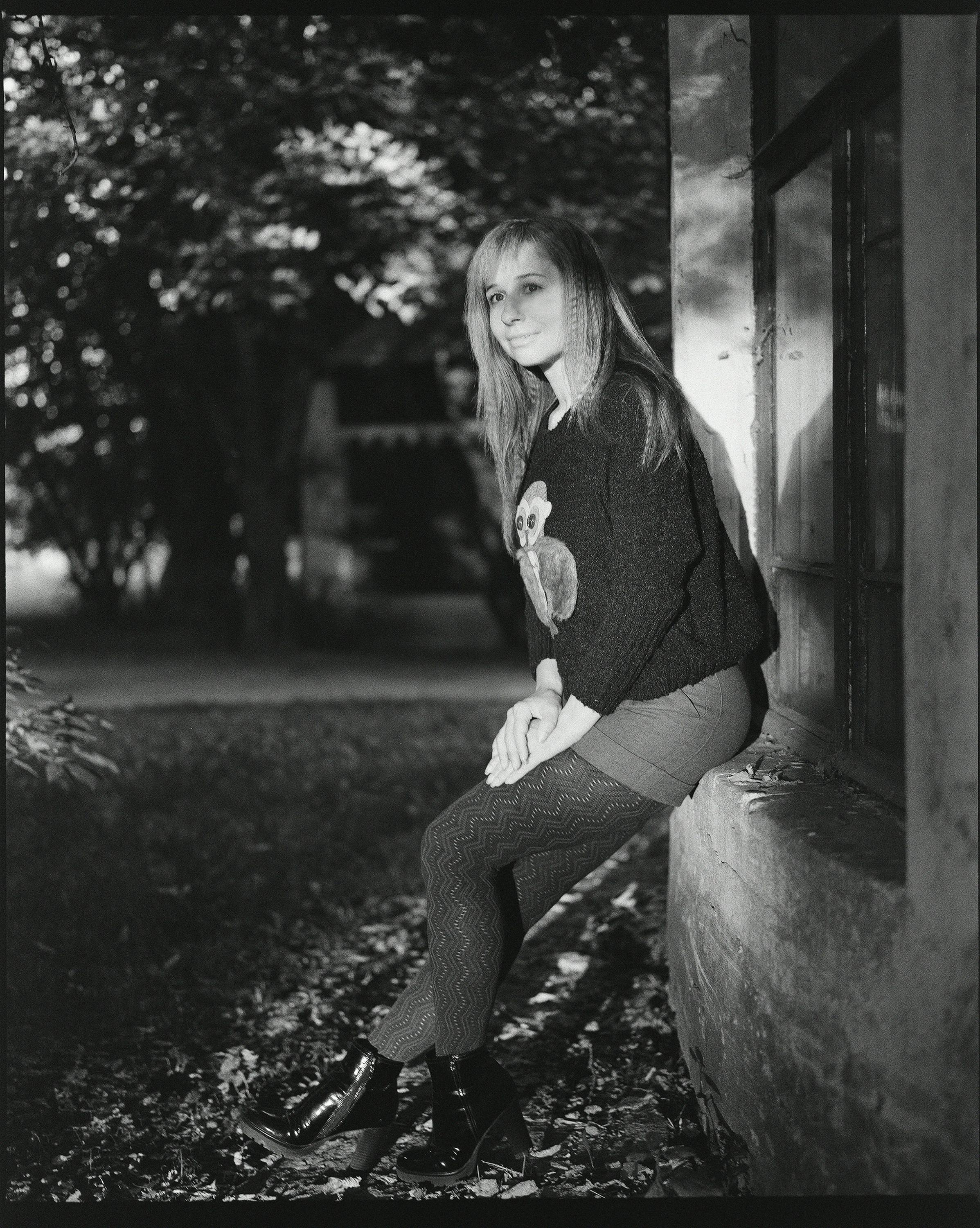 Woman in Sweater and Skirt Posing on Windowsill · Free Stock Photo