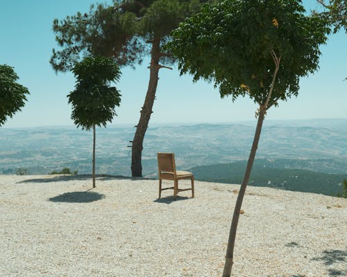 A Chair Standing on a Cliff Overlooking Hills 