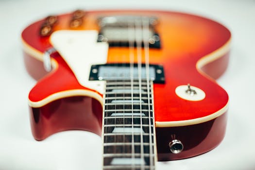 Detailed close-up image of an electric guitar showcasing its neck and body in vibrant hues.