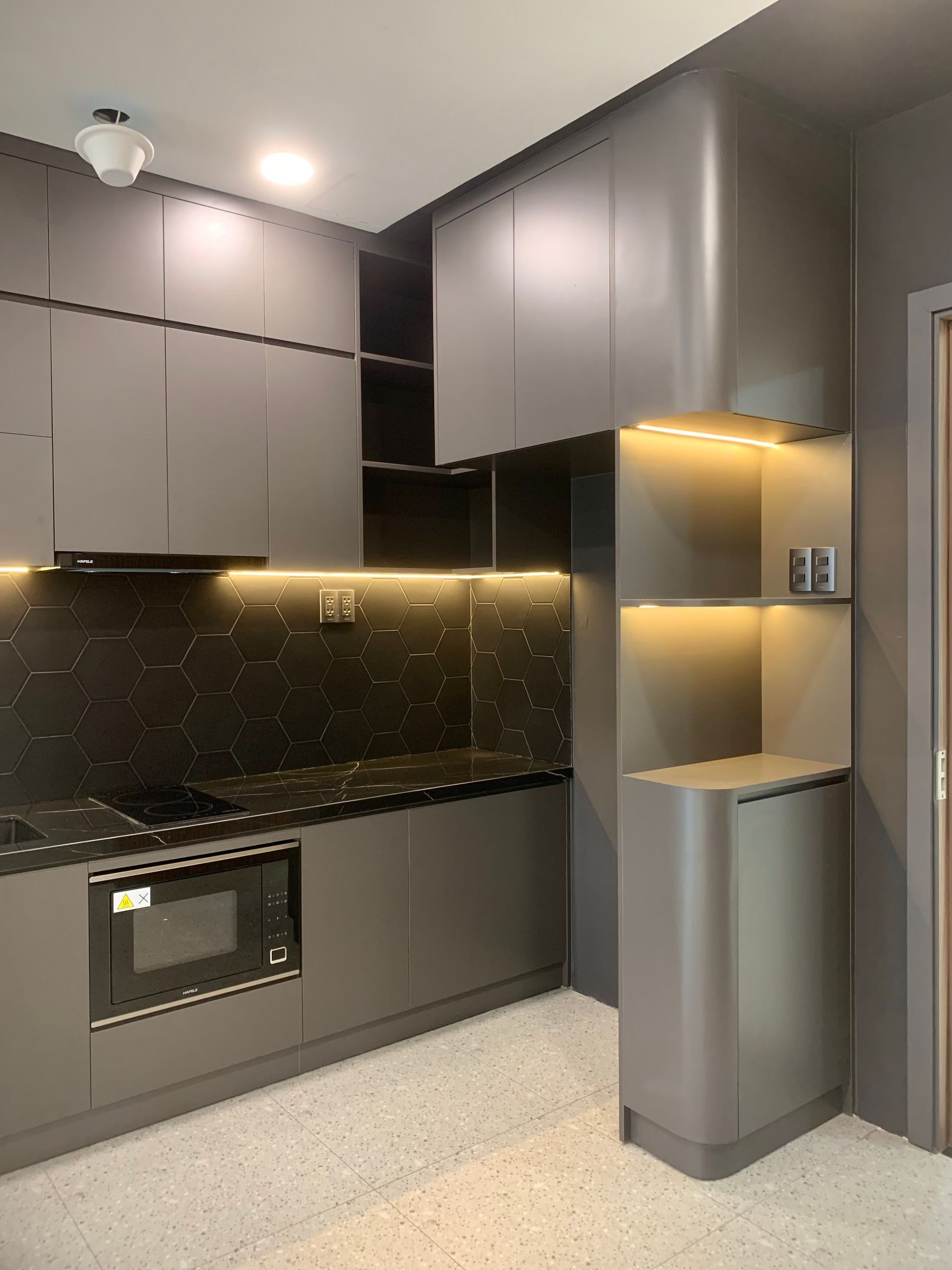 Compact grey kitchen with sleek cabinetry and soft integrated ambient lighting