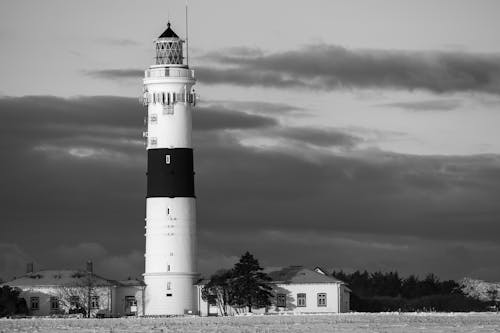 Black and White Photo of a Lighthouse against Dark Clouds