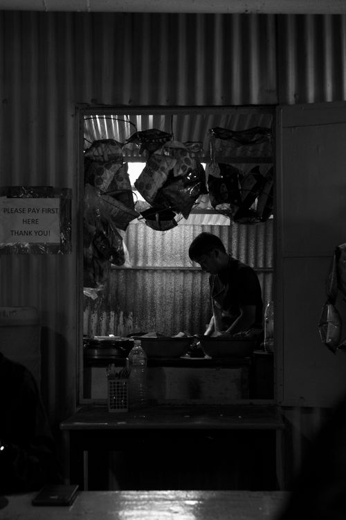 Free A man preparing food in a dimly lit kitchen in Kathmandu, Nepal. Stock Photo