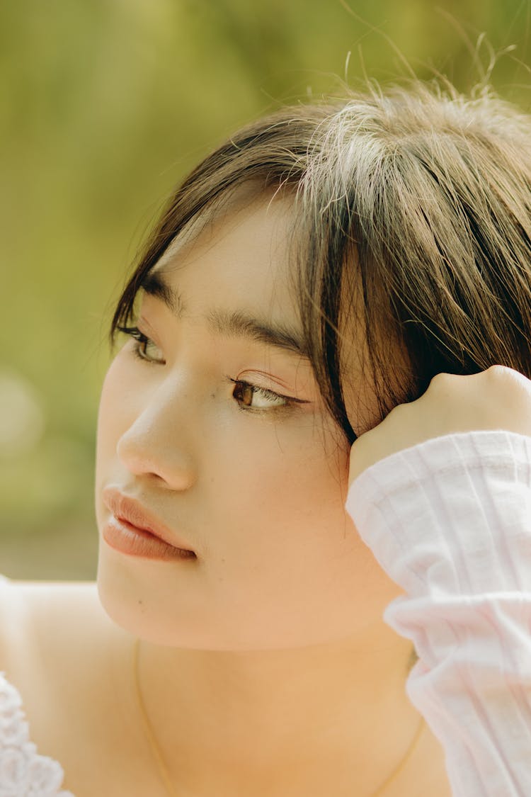 Young Woman Sitting Outside And Looking Away 