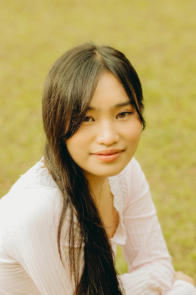 Portrait Of A Young Woman Sitting Outside And Smiling 