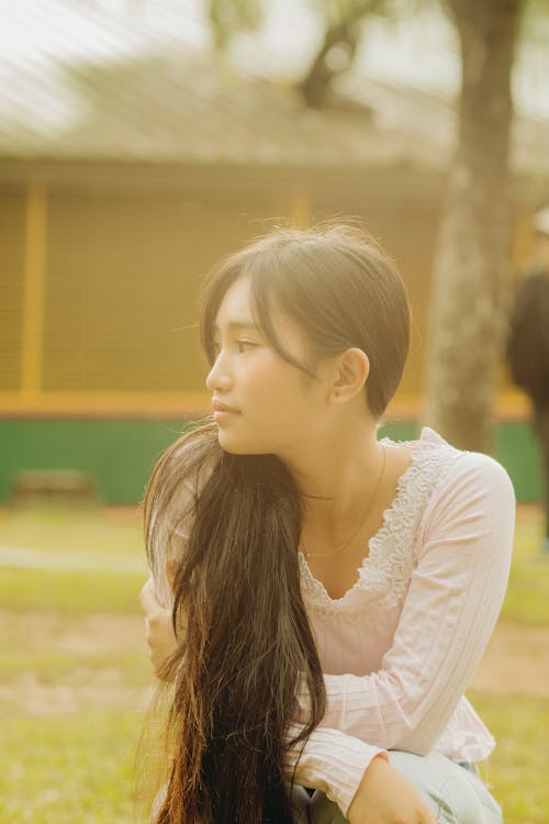 Young Woman Sitting in a Park and Looking Away 