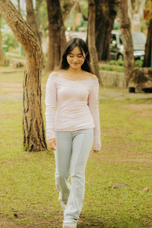 Young Woman Walking in a Park and Smiling