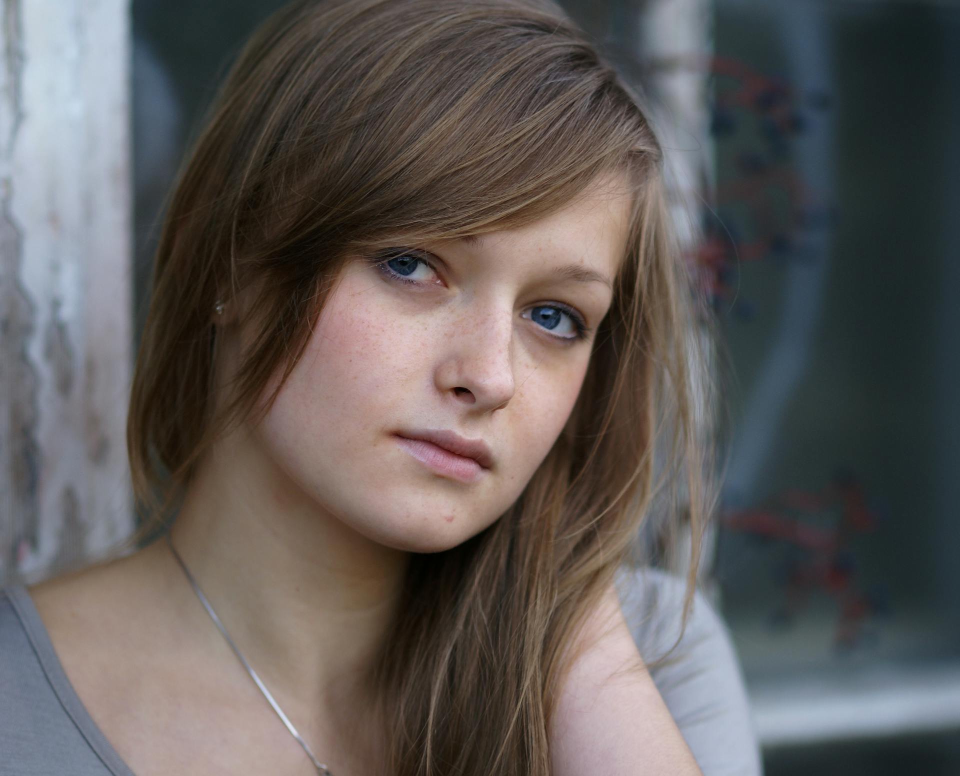 A young woman with long hair and a gray shirt