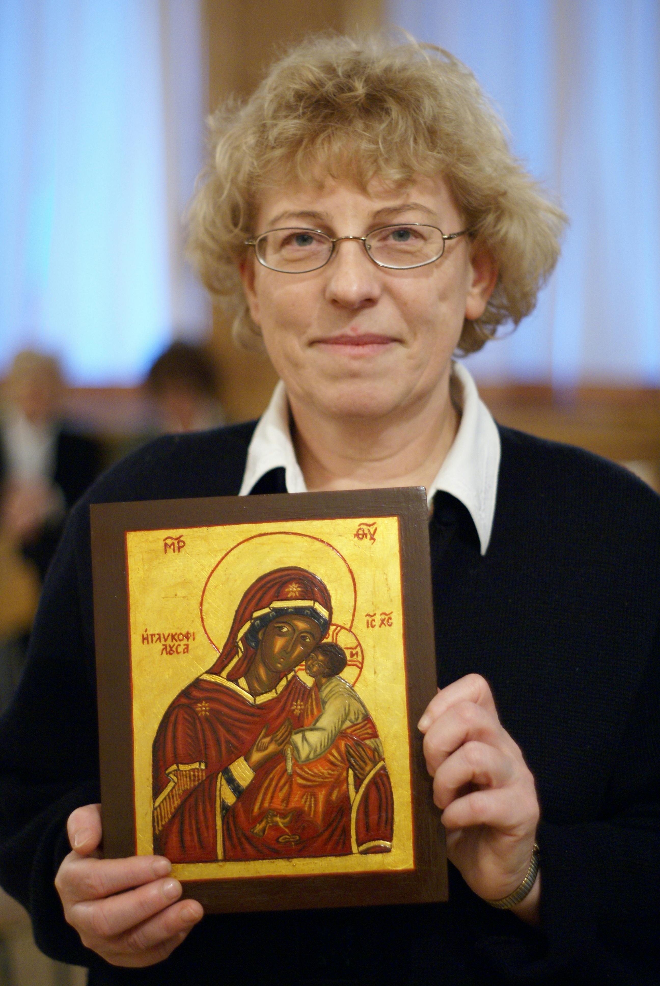 Caucasian woman displays a religious icon in Wrocław, Poland.