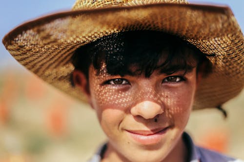 Face of a Smiling Boy Wearing a Hat