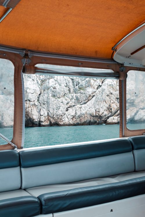 Free A peaceful view of rocky cliffs seen through a boat's window on a calm day. Stock Photo