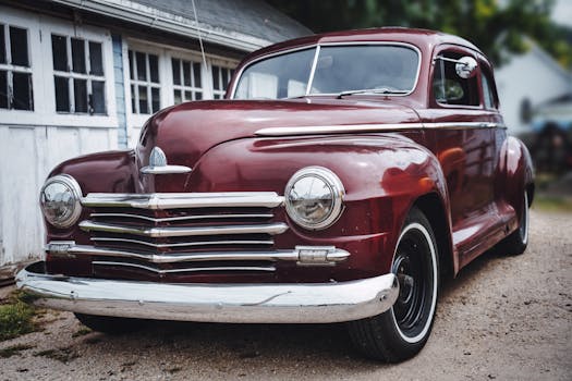 A beautifully restored vintage red car parked in a rustic garage setting in Nelson, WI.