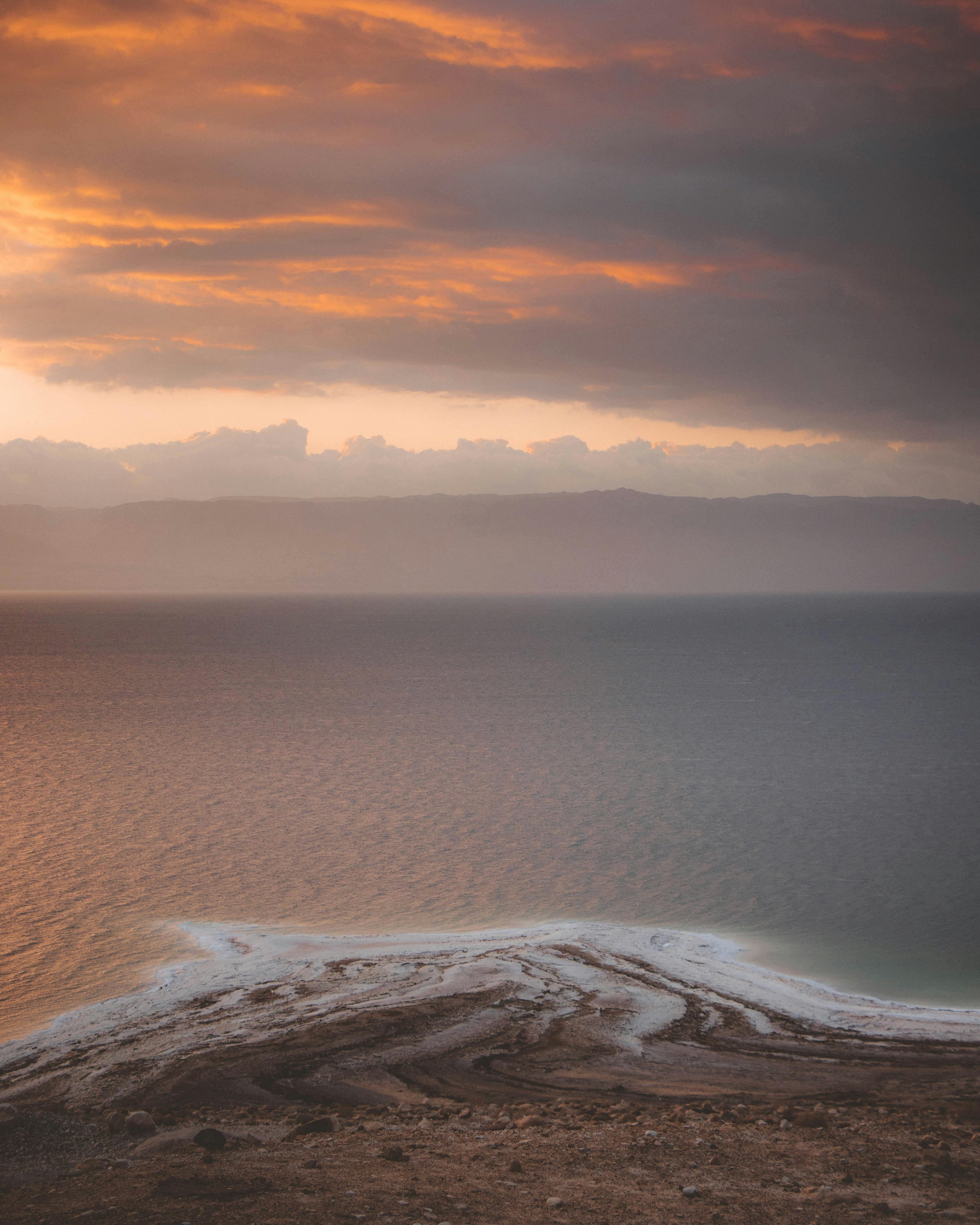 A breathtaking view of the ocean at sunrise, featuring vibrant colors and dramatic clouds.