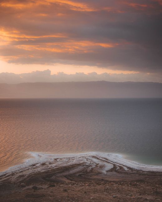 A breathtaking view of the ocean at sunrise, featuring vibrant colors and dramatic clouds.