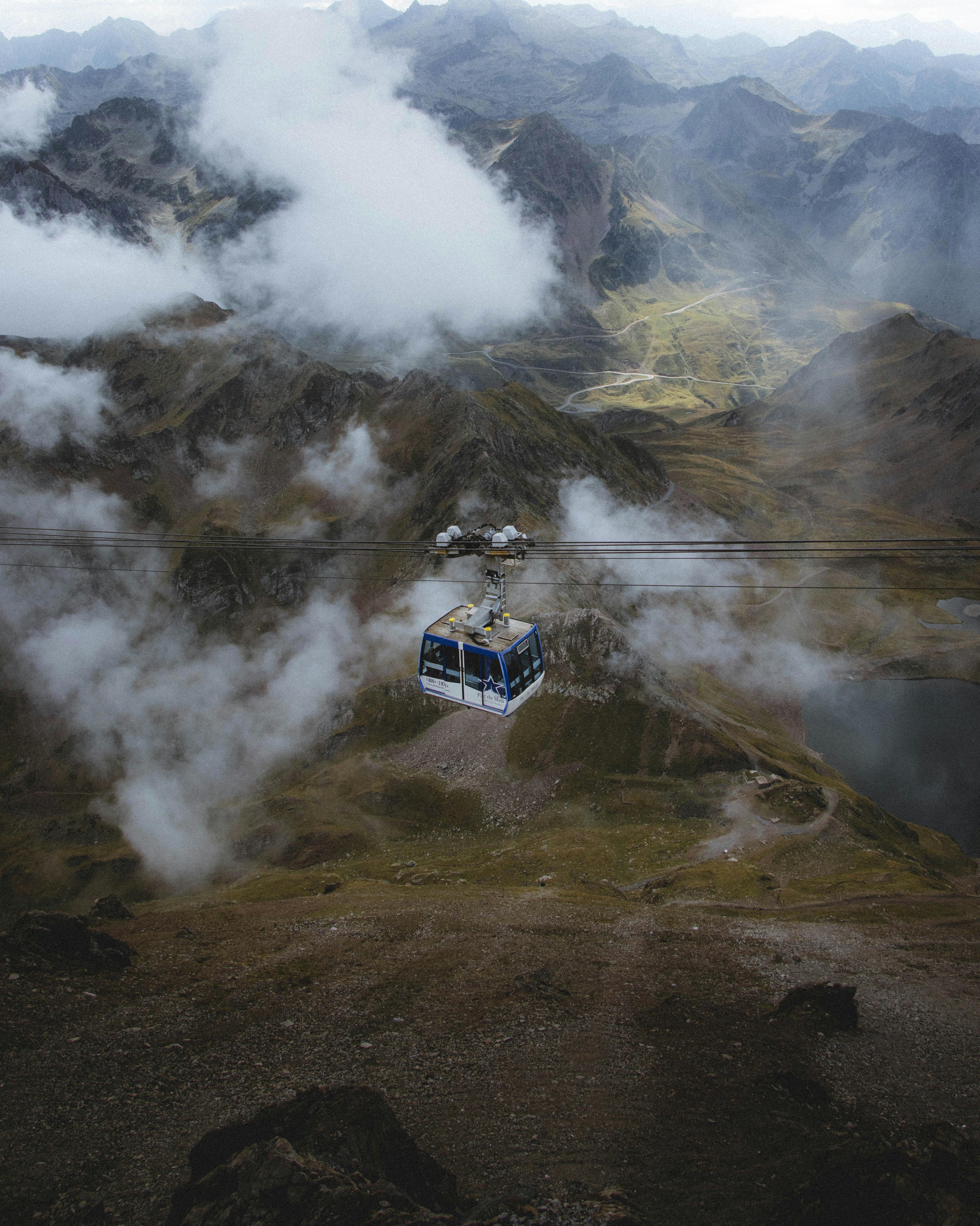 Breathtaking view of a cable car traversing a misty alpine mountain landscape.