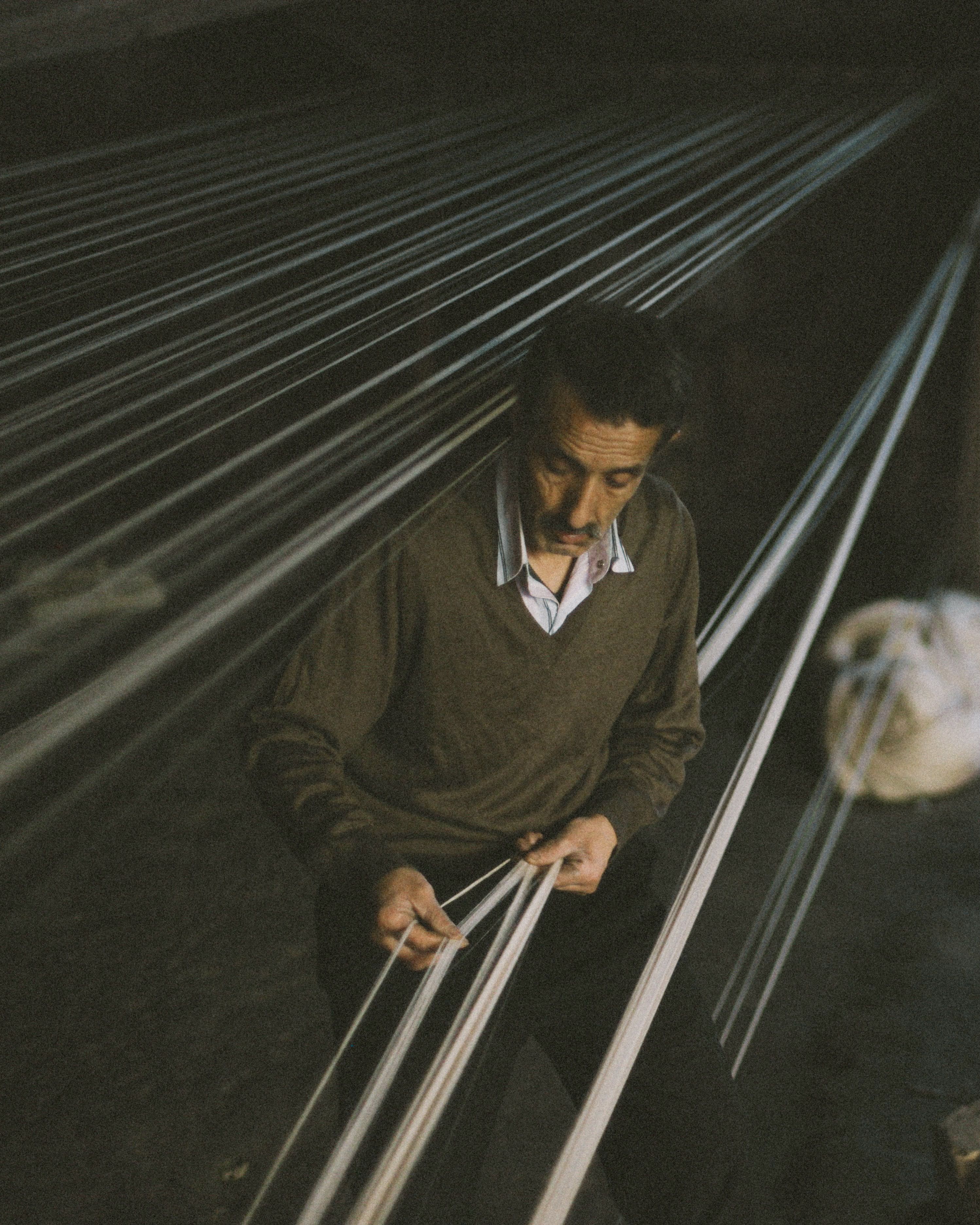 Portrait of a weaver at a wooden floor loom