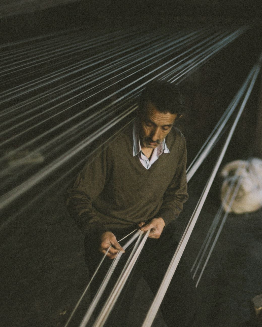 Portrait of a weaver at a wooden floor loom