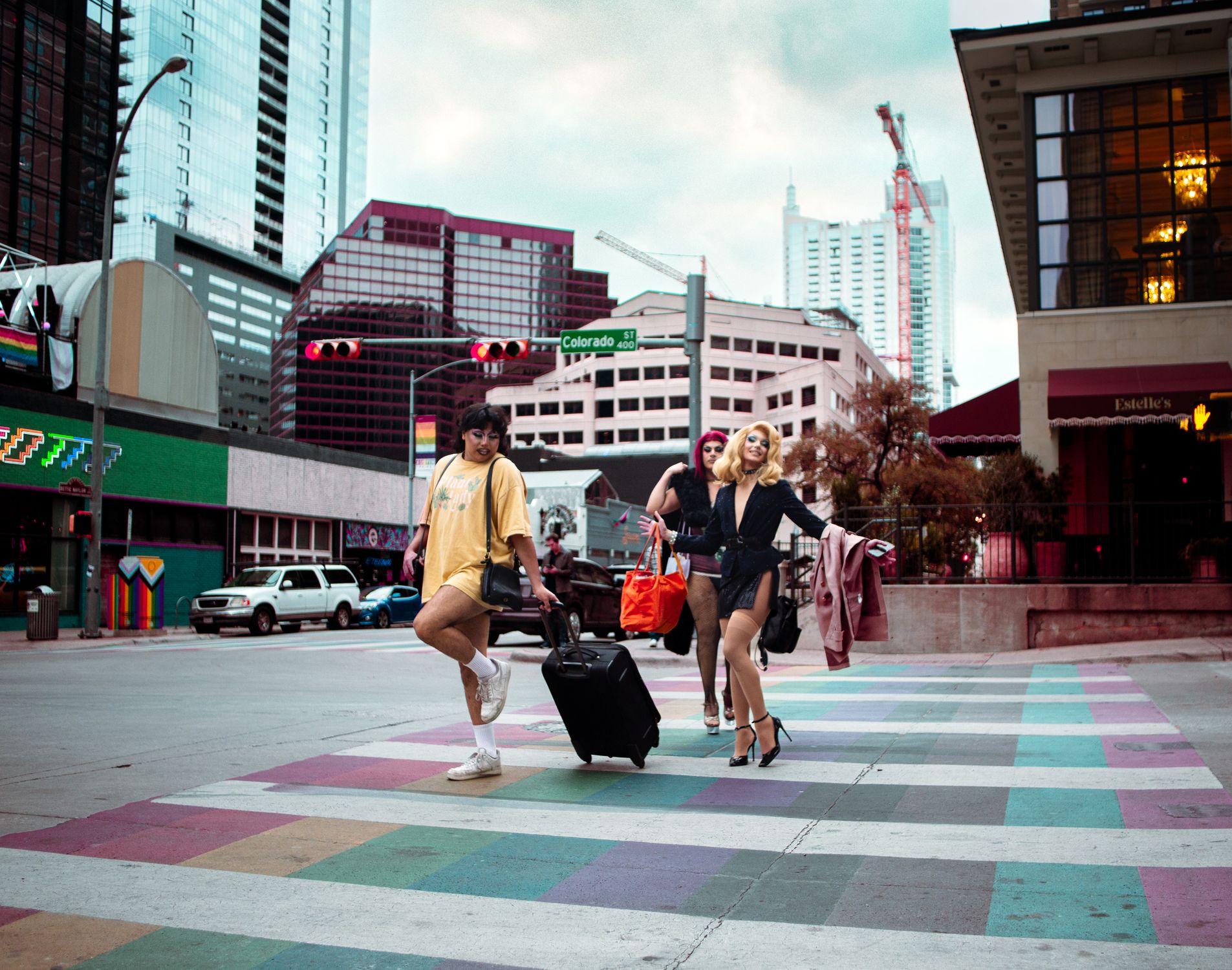 Trendy individuals crossing colorful city street in downtown Austin, Texas.